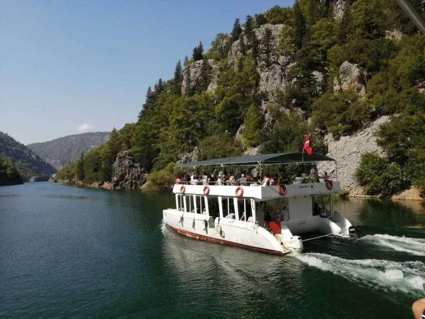 A double-deck catamaran moving between the limestone walls of the Green Canyon